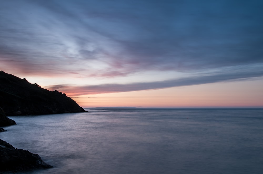 a long exposure photo of a sunset over the ocean