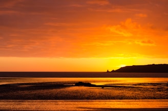 A vibrant sunset over El Nido's limestone cliffs reflecting on calm turquoise waters.