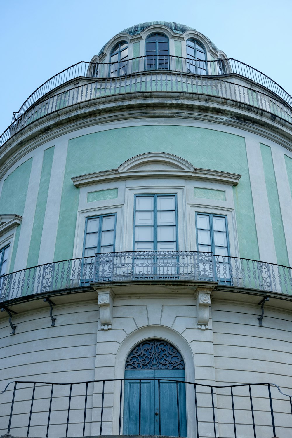 a large building with a blue door and balcony