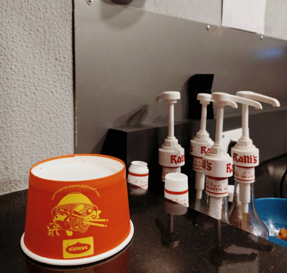 a counter with several bottles of mouthwash and a bowl of toothpaste