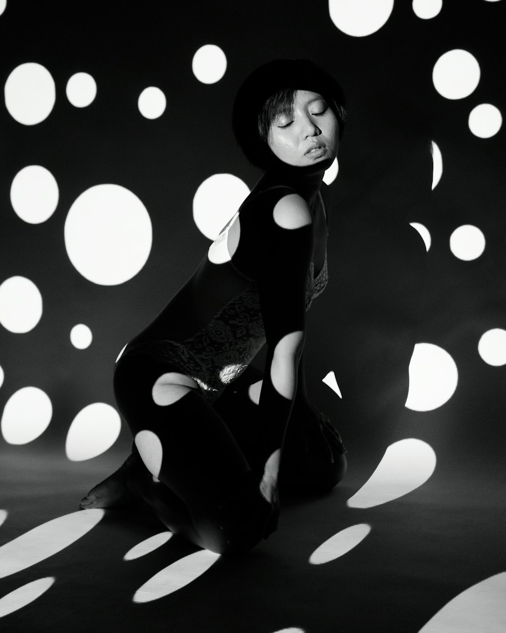 a woman sitting on the ground in a black and white photo