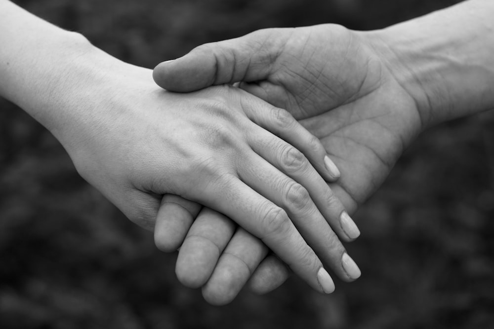 a couple of people holding hands over each other