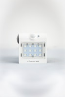 A square white LED light fixture featuring twelve small illuminated LED bulbs arranged in a grid. The fixture has a white casing with a small, round motion sensor above the LED grid and a branding label at the bottom.