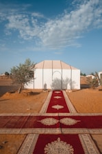 A panoramic view of a luxury tent setup in the desert with decorative elements and guests enjoying the event.
