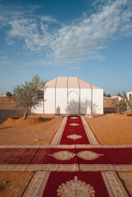 A panoramic view of a luxury tent setup in the desert with decorative elements and guests enjoying the event.