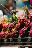 Close-up of ripe red dragon fruits stacked neatly in wooden crates at the Miami warehouse.