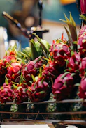 Fresh pitahaya fruits displayed on rustic wooden crates with green leaves