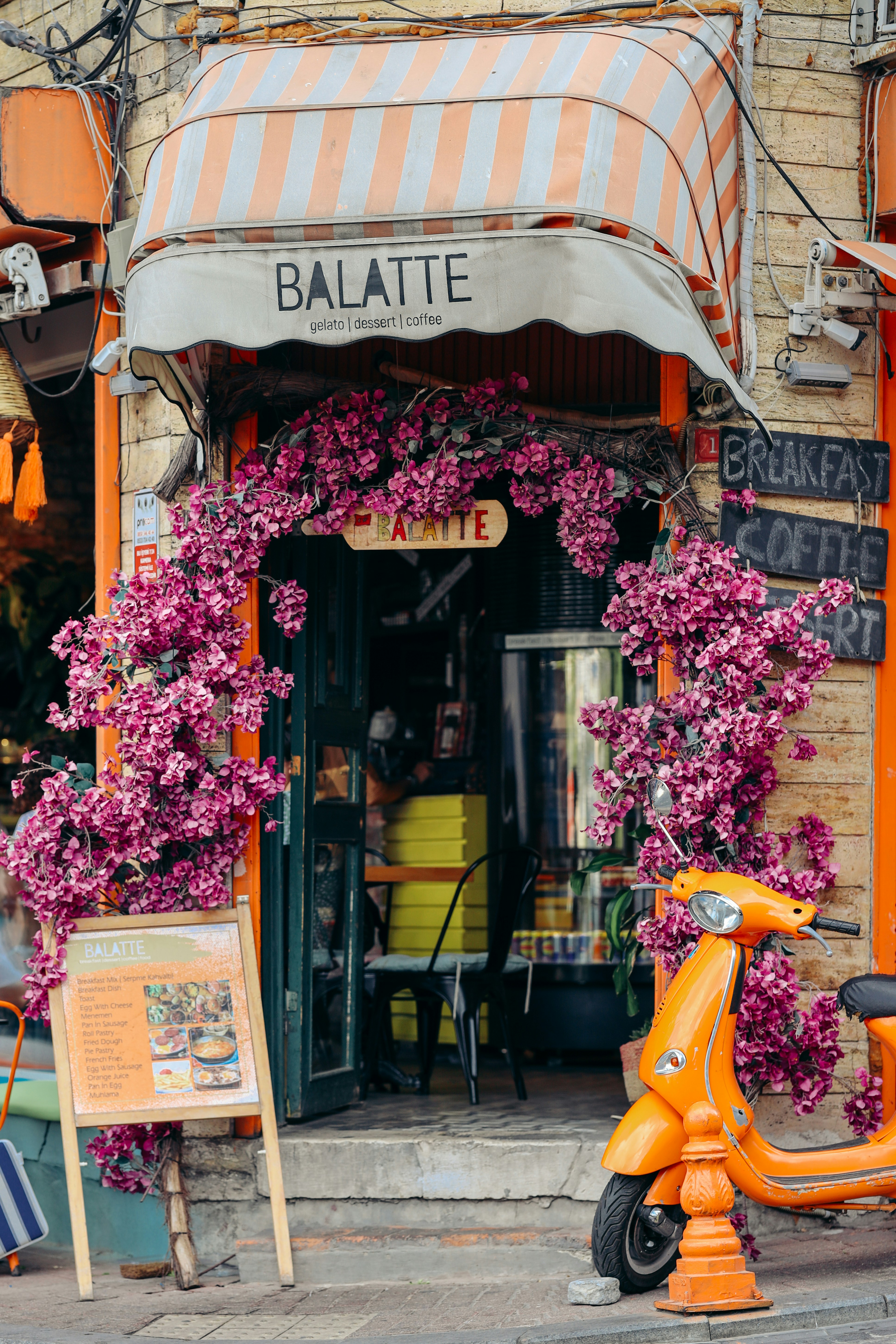 a scooter parked outside of a flower shop