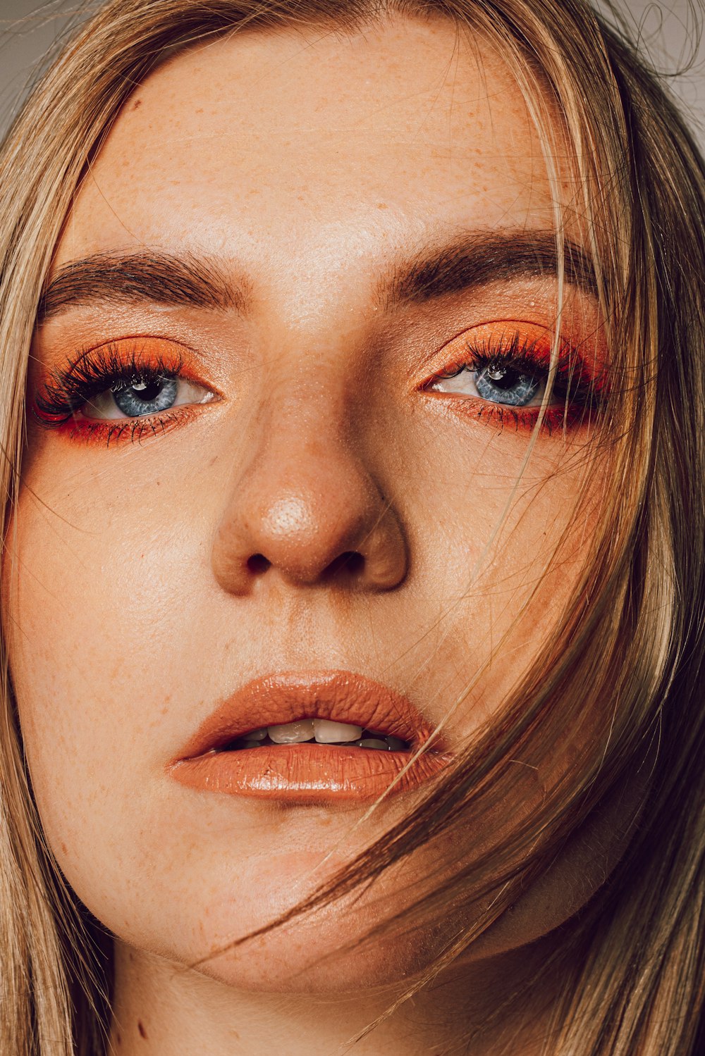 a close up of a woman with orange makeup