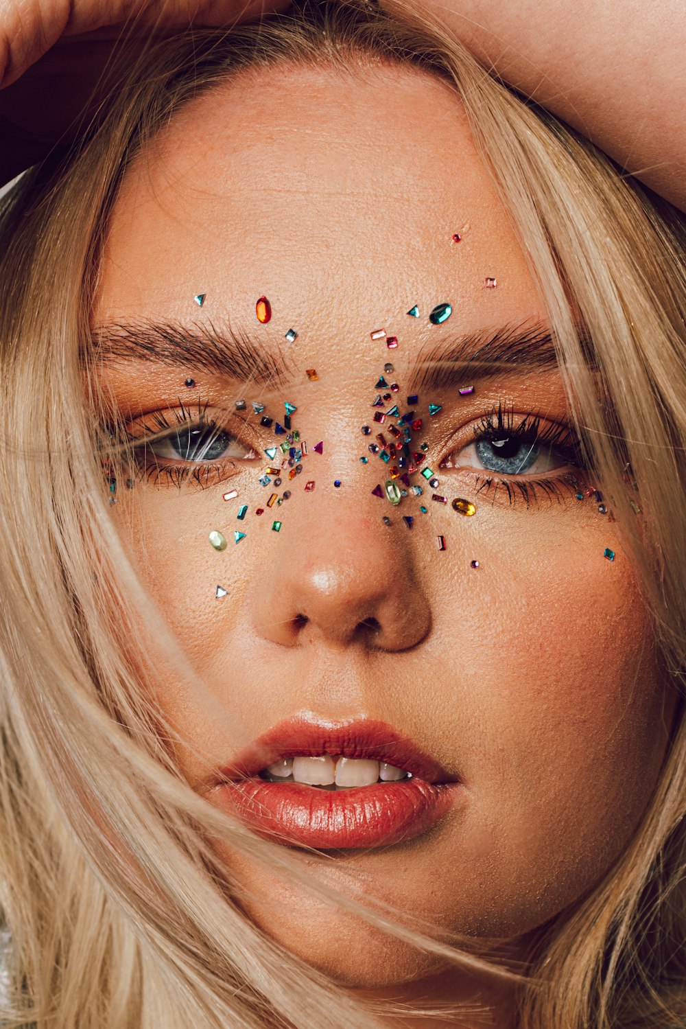 a blonde woman with colorful sprinkles on her face