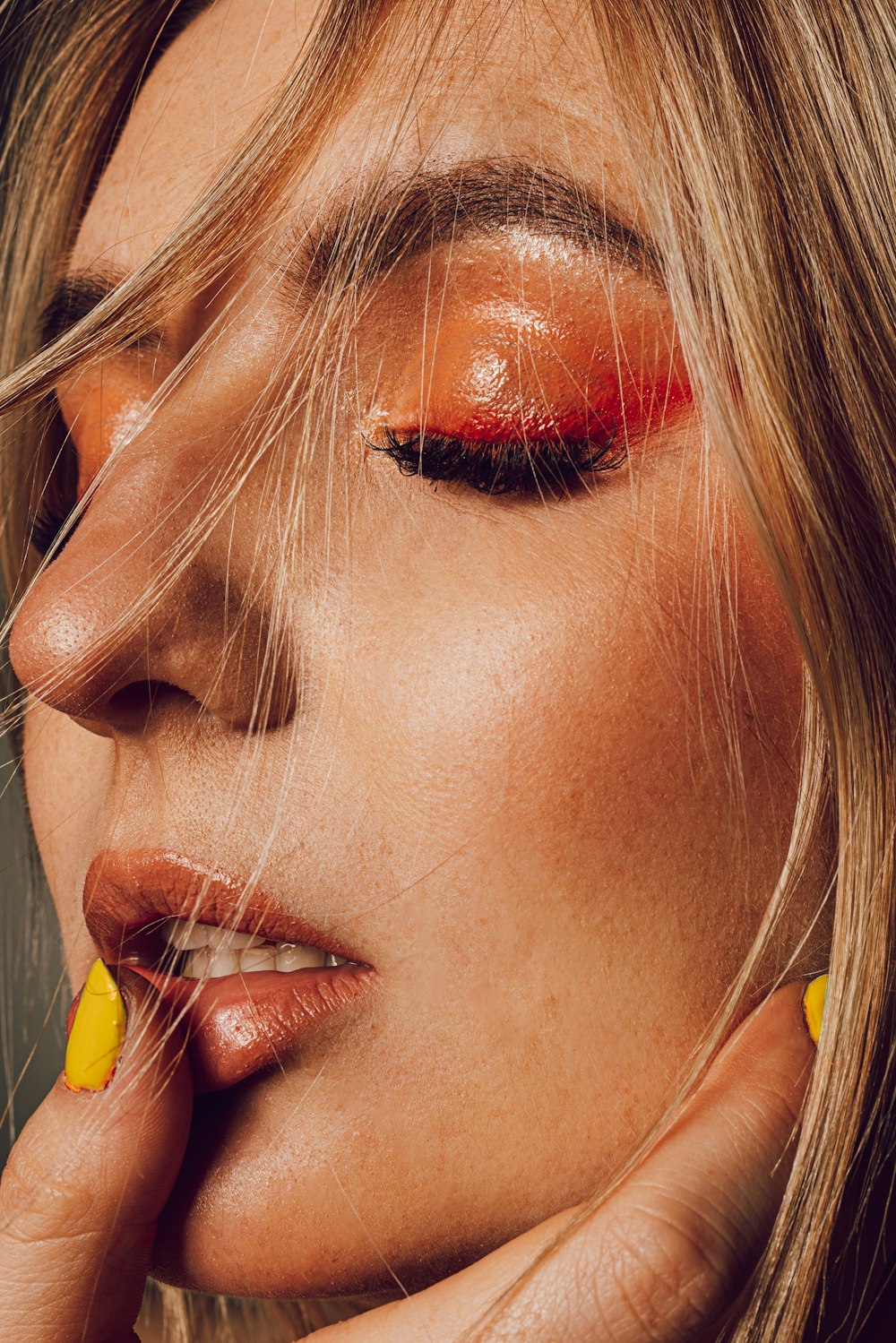 a woman with yellow nails and a red lip