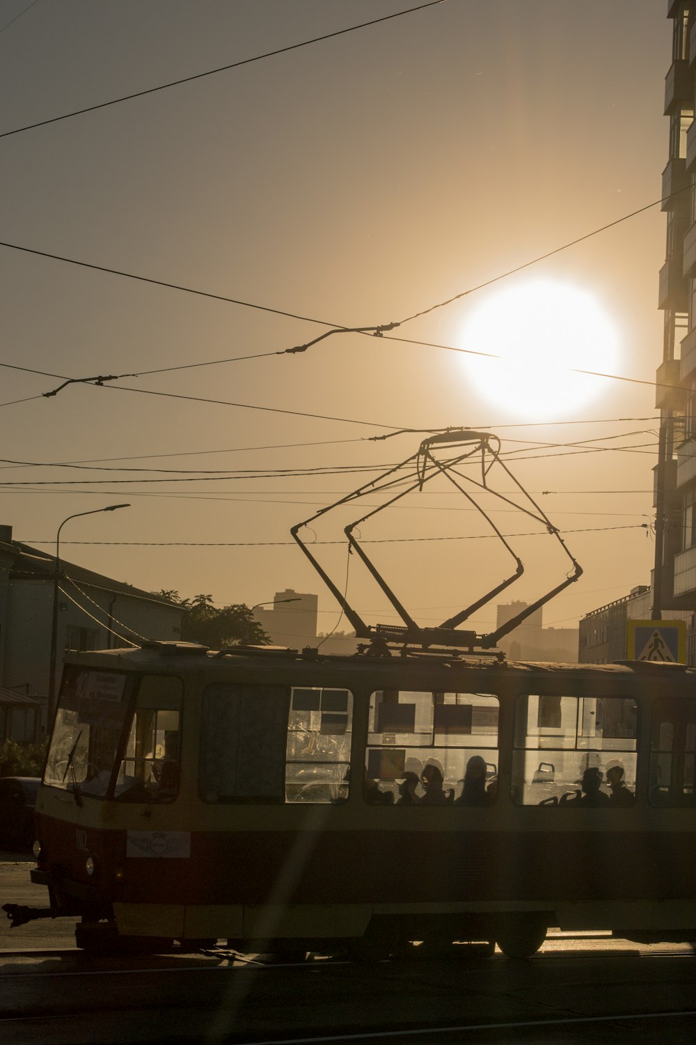 the sun is setting behind a trolley on the street