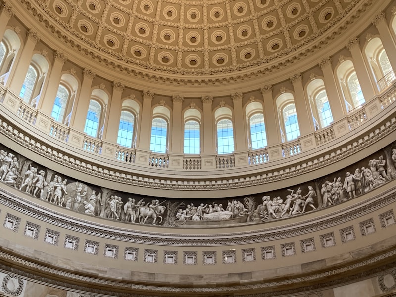 Interior of the US Capitol rotunda dome with ornate frieze and columns