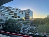 Modern office building with glass facade at sunset.