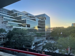 Modern office building with glass facade at sunset.