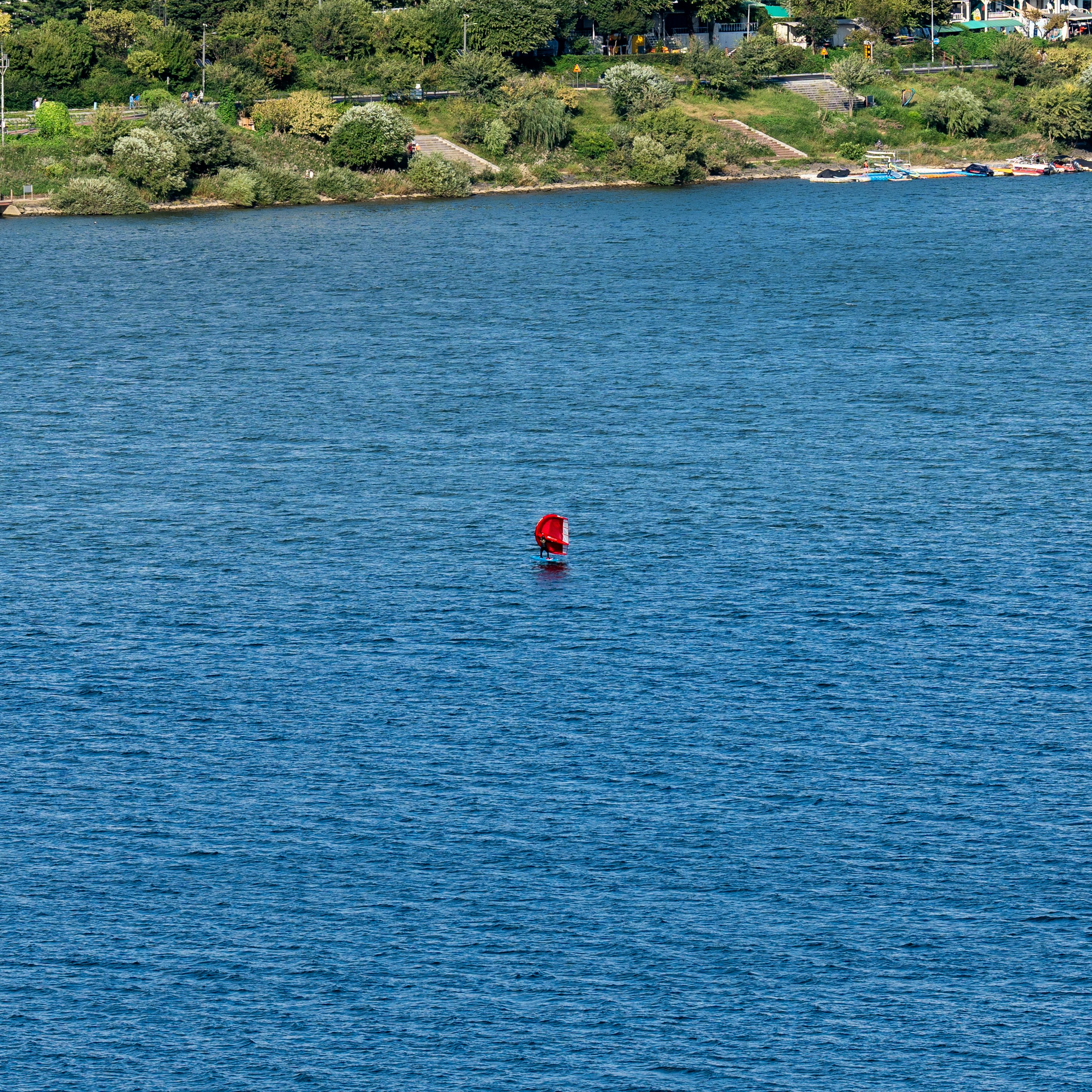 A red buoy floating in the middle of a lake photo Free Sea Image on Unsplash