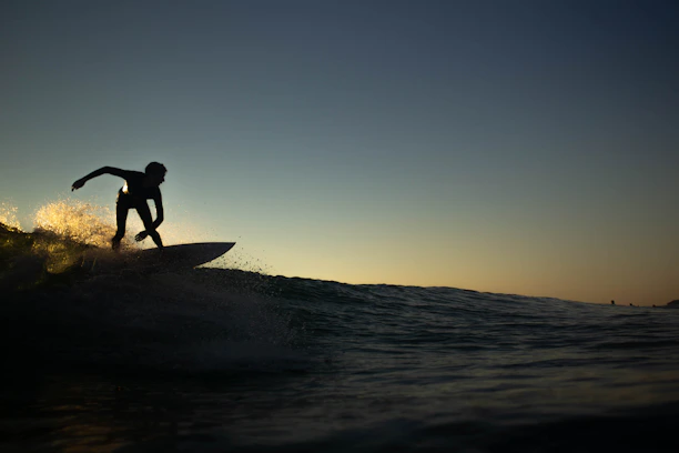 A vibrant photo of a surfer riding a wave at sunset, capturing the spirit of adventure.