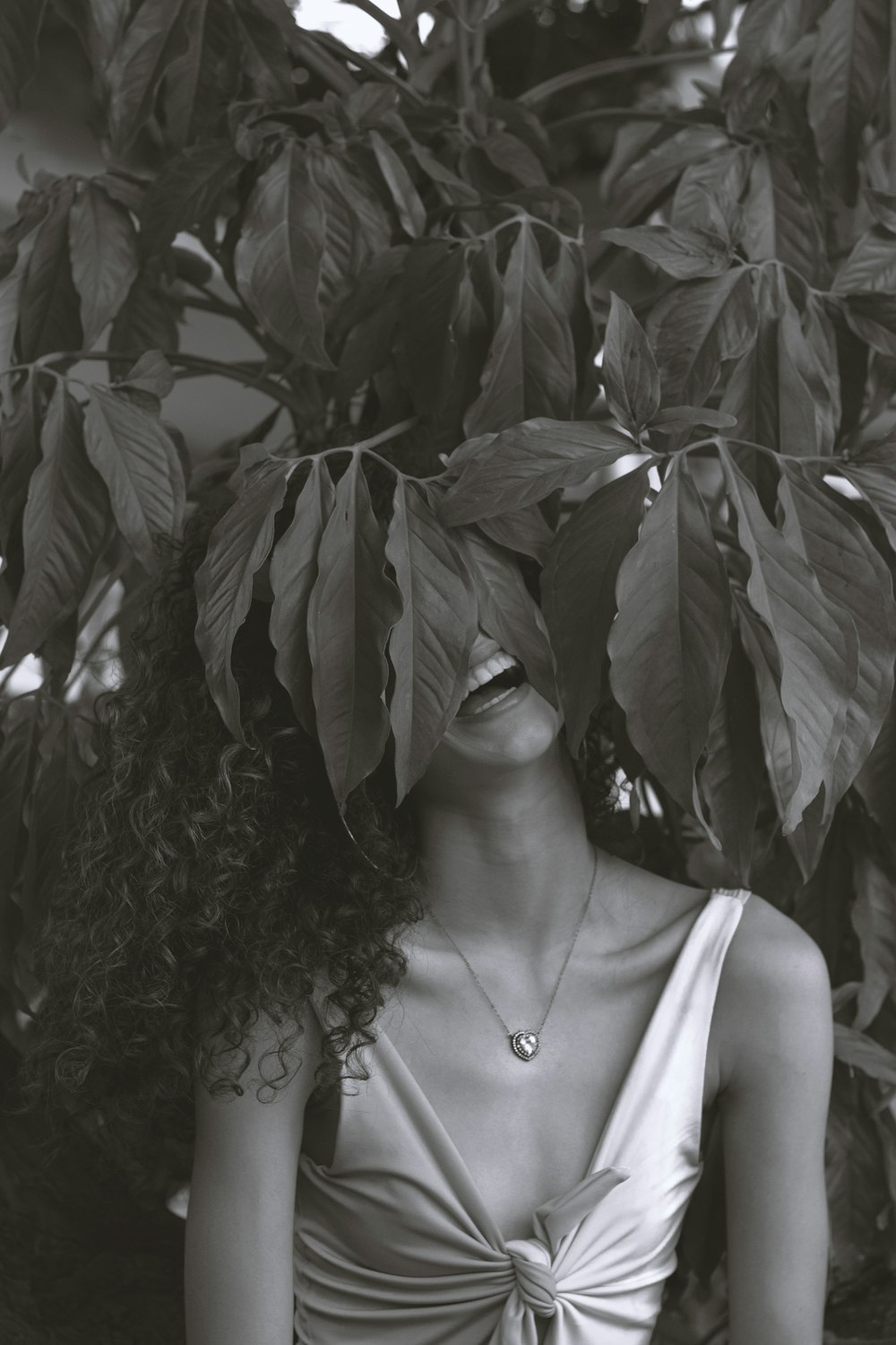 a woman in a dress sitting under a tree