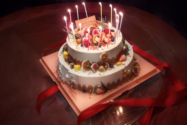 Close-up of a beautifully decorated eggless birthday cake with vibrant fruit toppings.