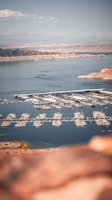 Aerial view of a coastal marina with boats docked under clear skies.