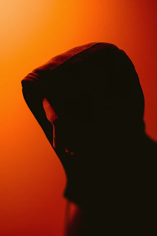 Shadowed profile of a model against a dark backdrop, highlighting a sweatshirt with a modernized Minotaur motif.