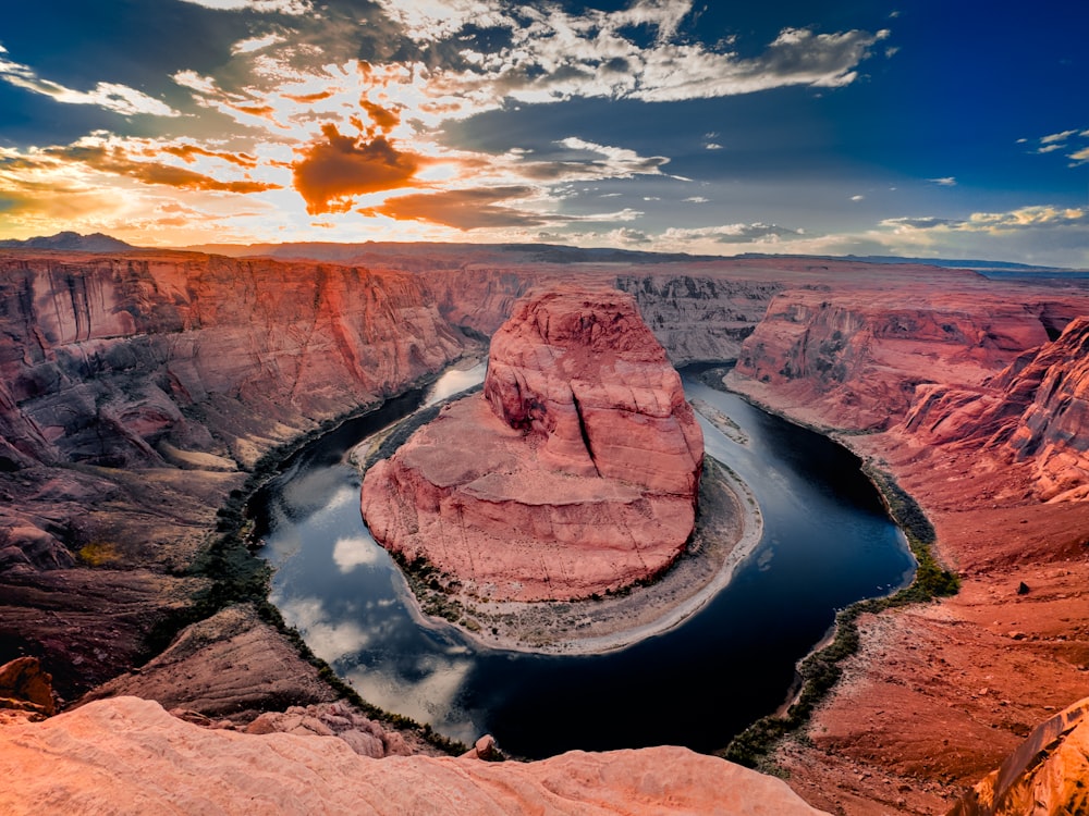 the sun is setting over a river in a canyon