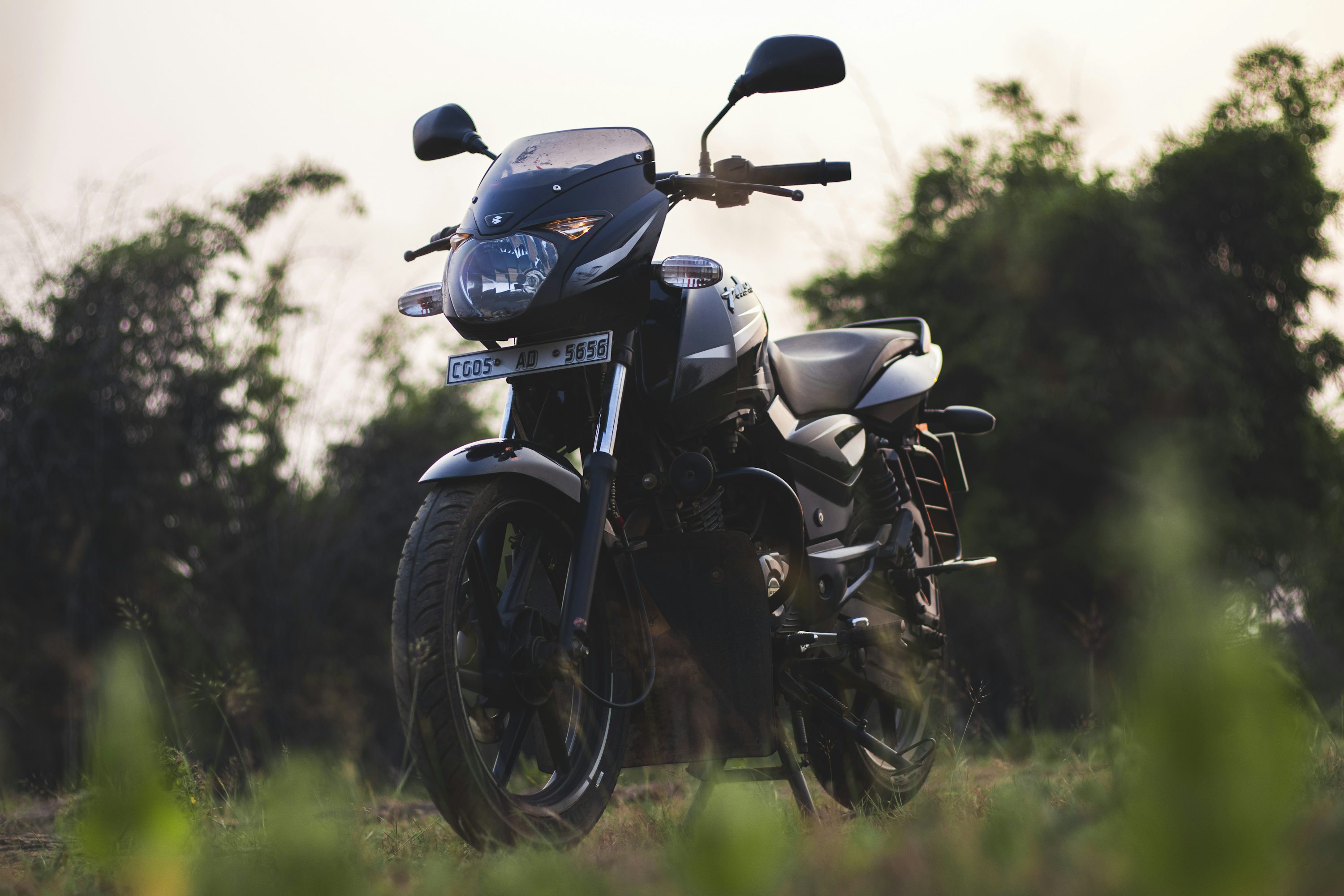 a black motorcycle parked in a grassy field