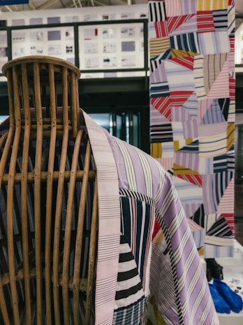 Close-up of artistic personal clothing with bold, bright patterns displayed on a mannequin.