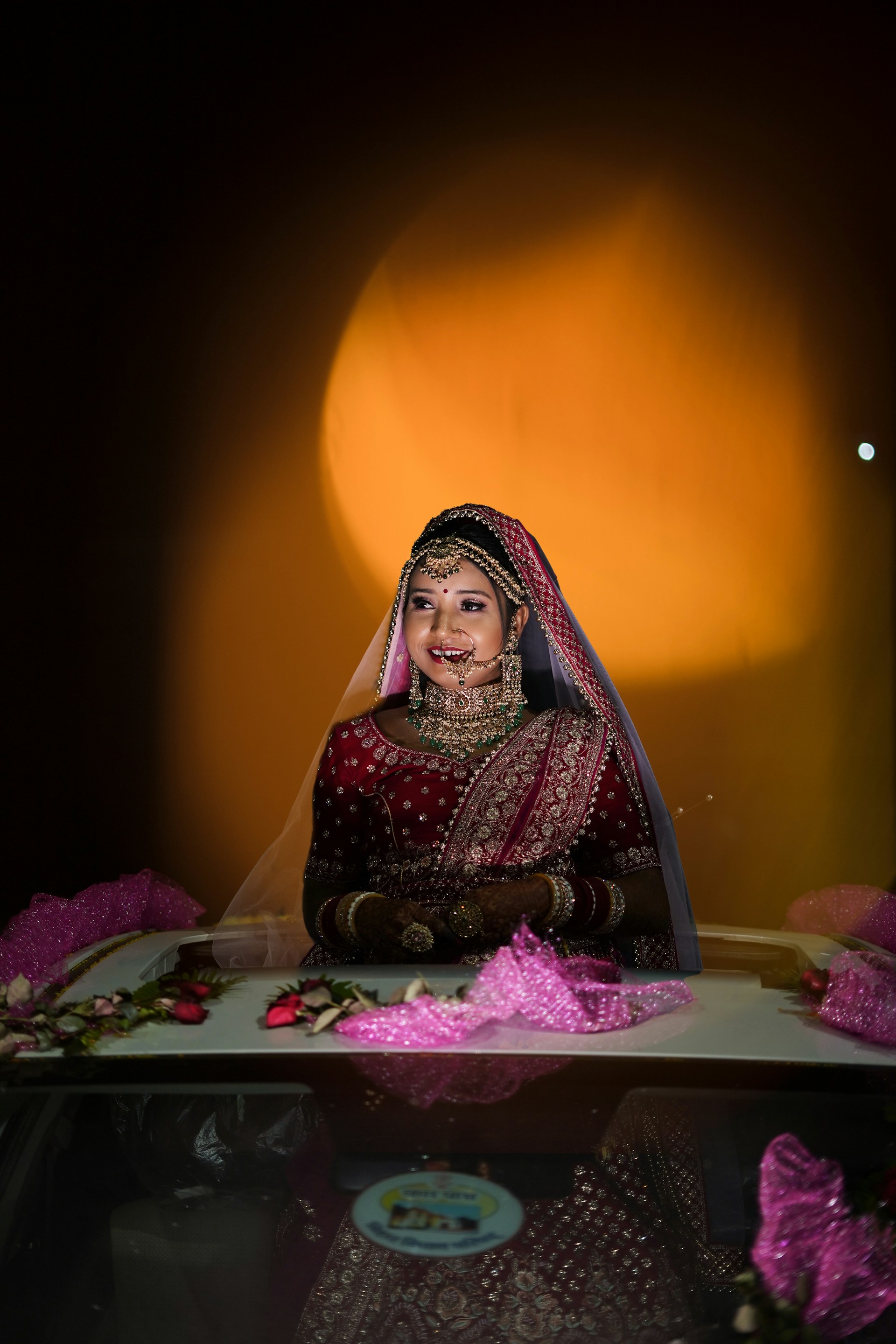 A radiant bride in traditional Indian attire, captured in a golden hour glow that highlights the intricate details of her jewelry and dress.