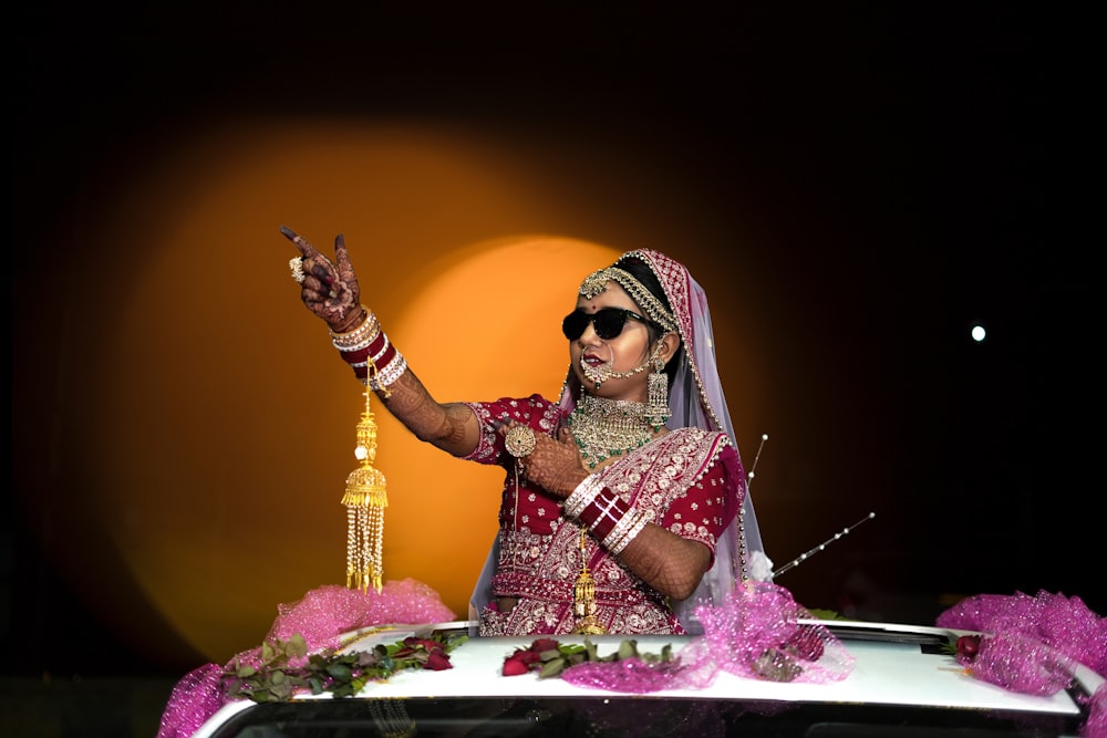 a woman in a red and white outfit is holding up her hand