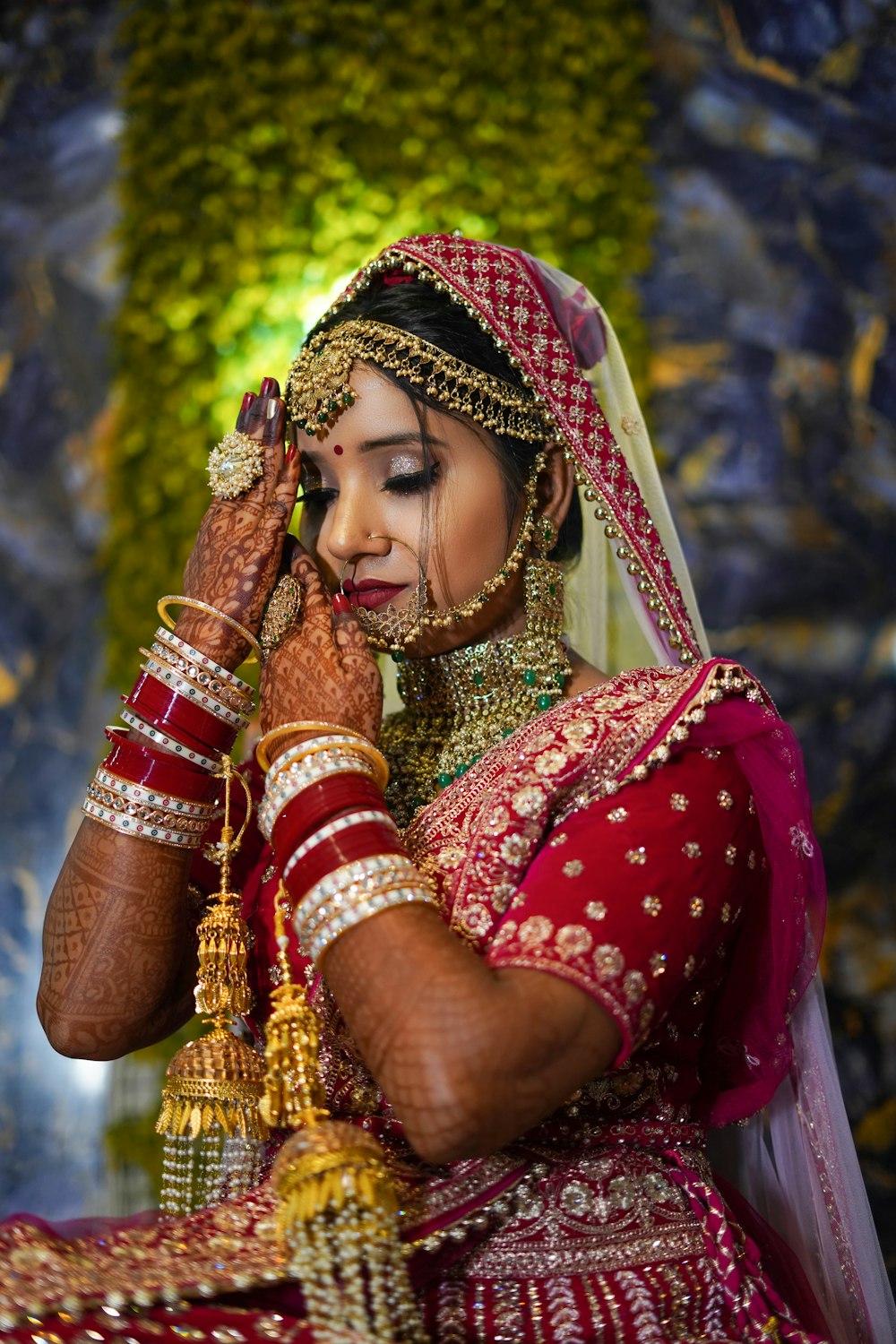 a woman in a red and gold bridal outfit