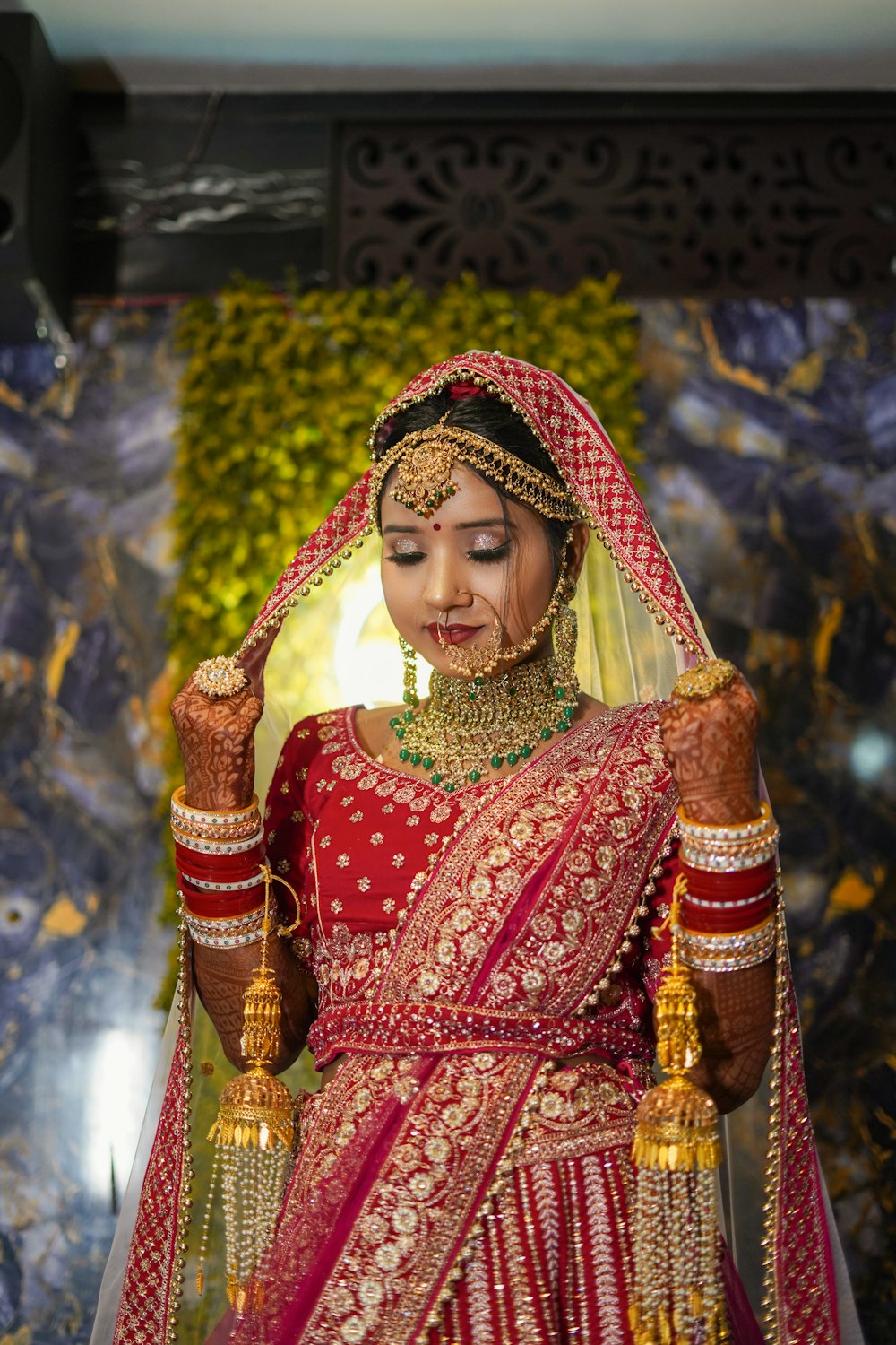 a woman in a red and gold wedding outfit