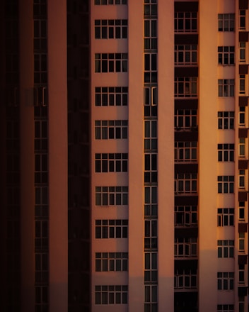 Golden and black themed high-rise residential building with sunlight casting warm glow.