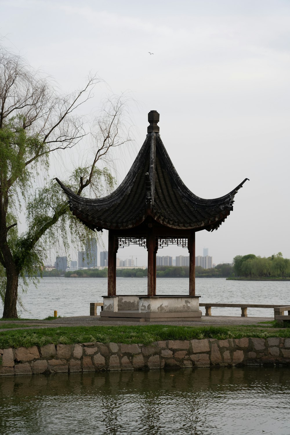 a gazebo in a park next to a body of water