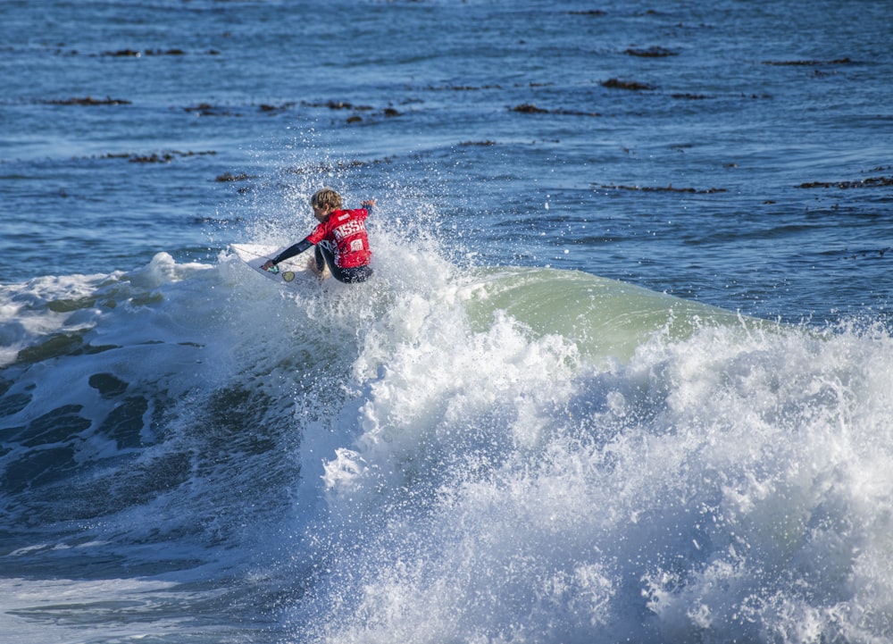 a man riding a wave on top of a surfboard