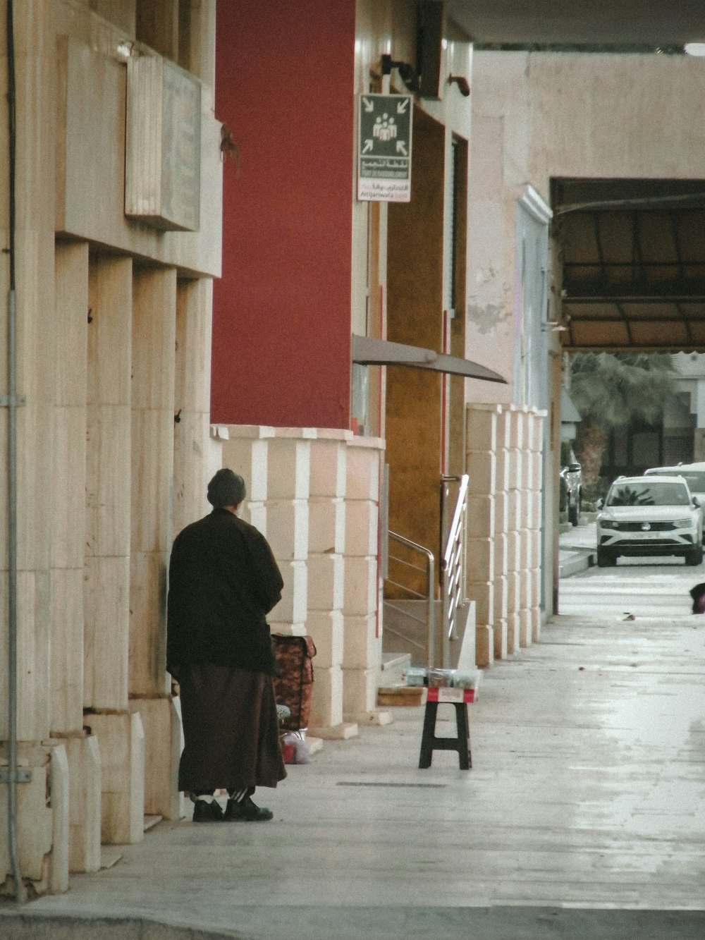 a man standing on a sidewalk next to a building