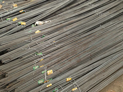 Rows of TMT bars neatly arranged in a large industrial storage facility.