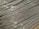 A large stack of steel rebar rods is neatly arranged, with labels and wires securing them at intervals. The rods have a ribbed texture and are uniformly aligned, extending diagonally from one corner of the image to the other.