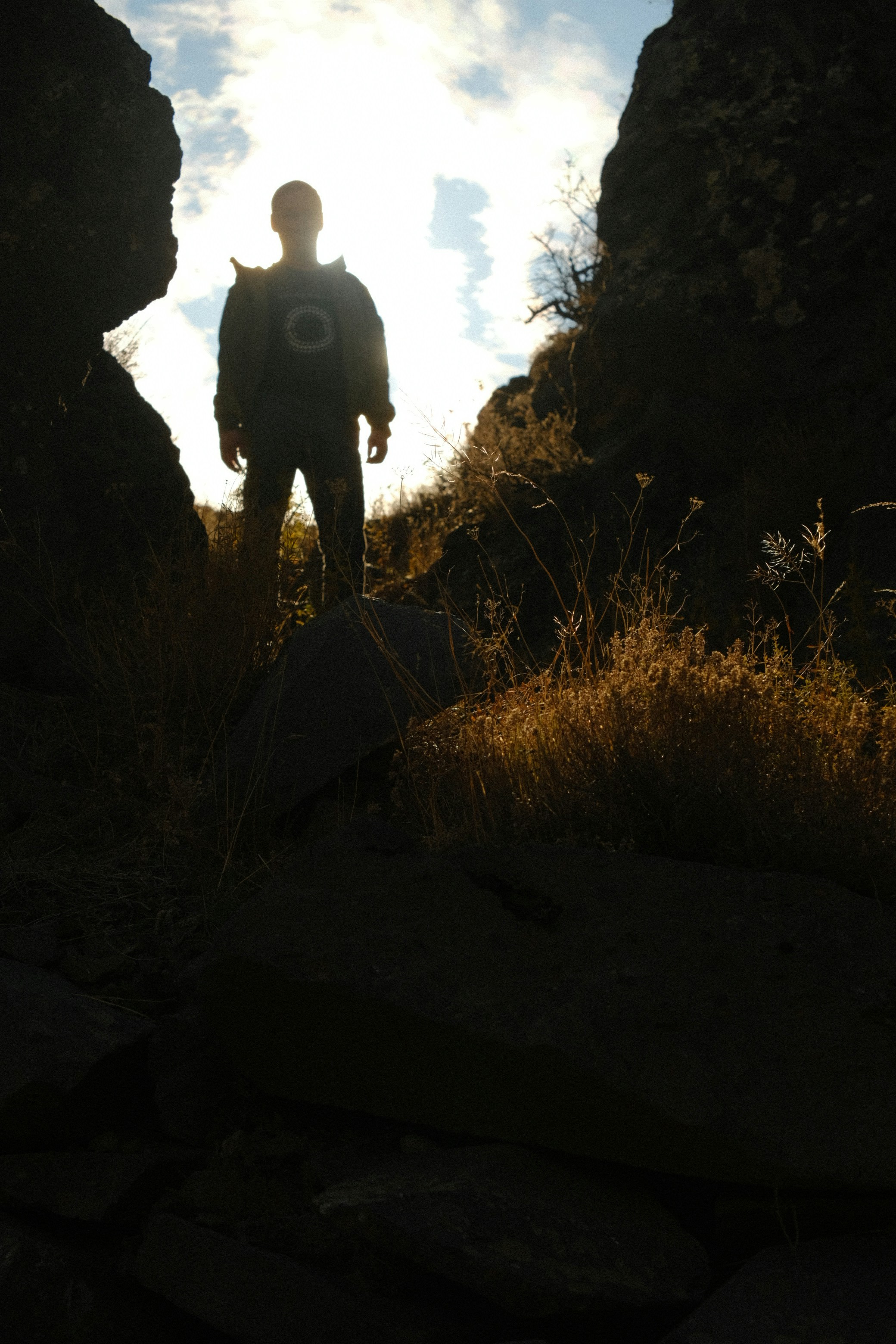 a man standing in the middle of a rocky area