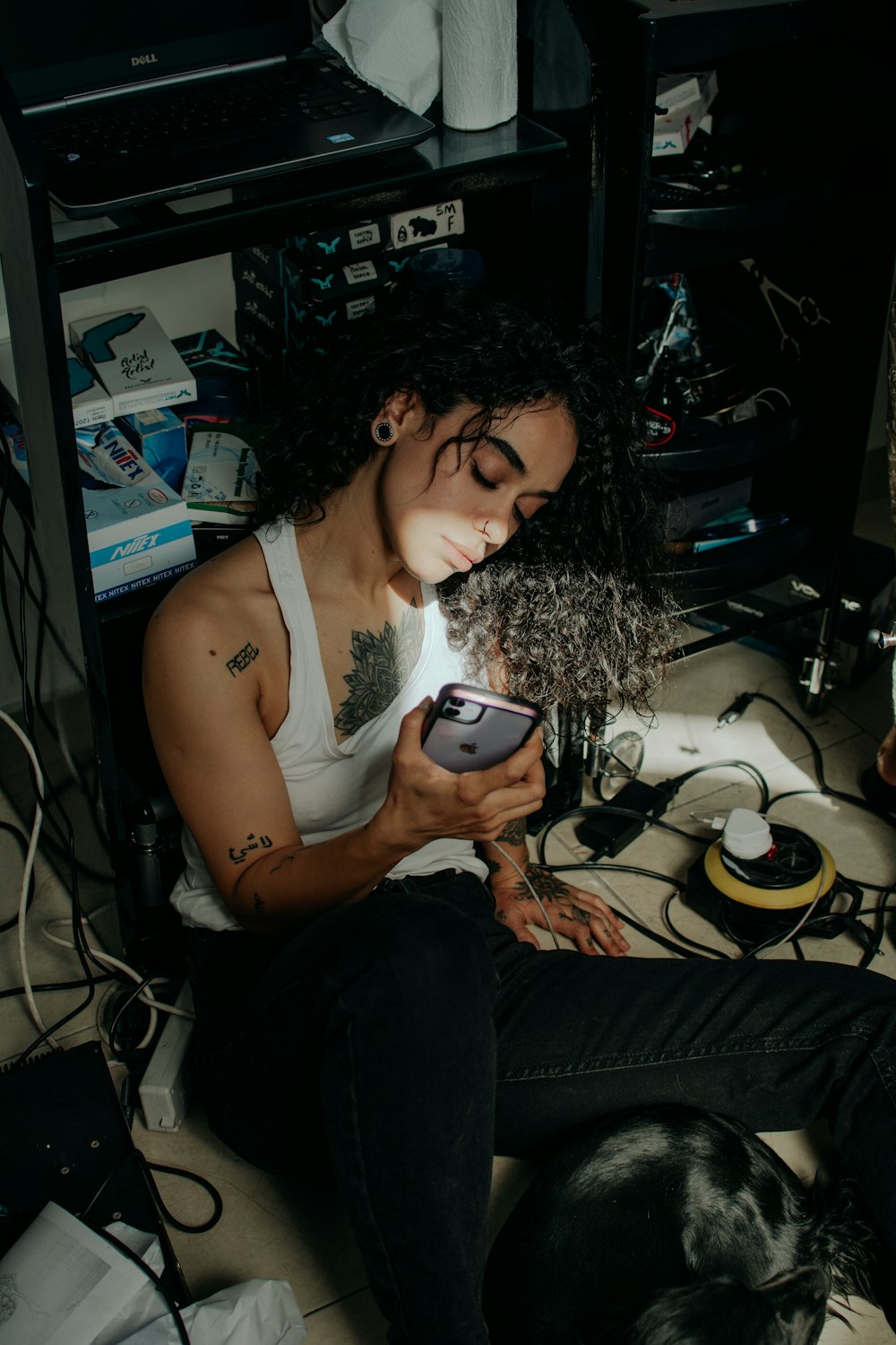 a woman sitting on the floor looking at her cell phone