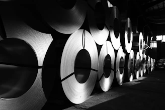 rolls of steel are lined up in a warehouse