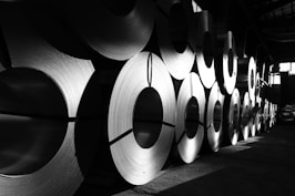 rolls of steel are lined up in a warehouse