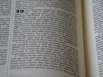 The image displays a close-up view of an open book, featuring a text layout in two columns with numbers indicating sections or verses. The page contains words that are clearly related to a religious text, mentioning terms like 'Sovereign LORD' and 'Israel'. The typography is traditional, suggesting a formal document.