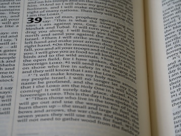 The image displays a close-up view of an open book, featuring a text layout in two columns with numbers indicating sections or verses. The page contains words that are clearly related to a religious text, mentioning terms like 'Sovereign LORD' and 'Israel'. The typography is traditional, suggesting a formal document.