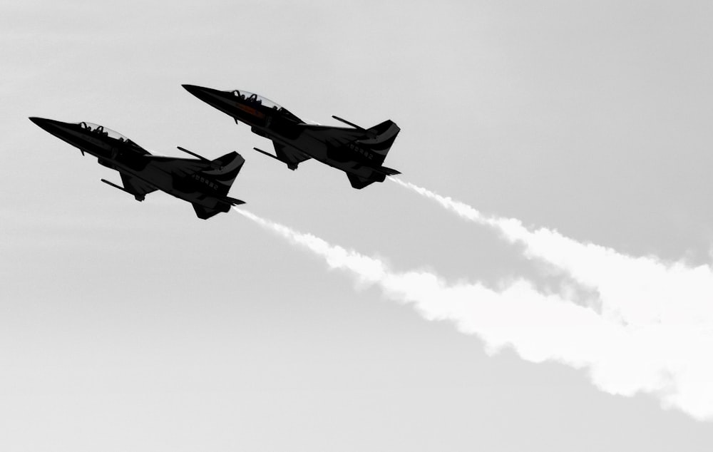 a couple of jets flying through a cloudy sky