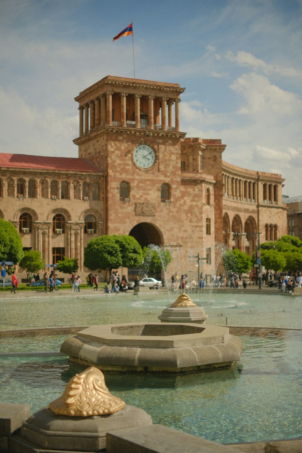 ein großes Gebäude mit einem Springbrunnen davor