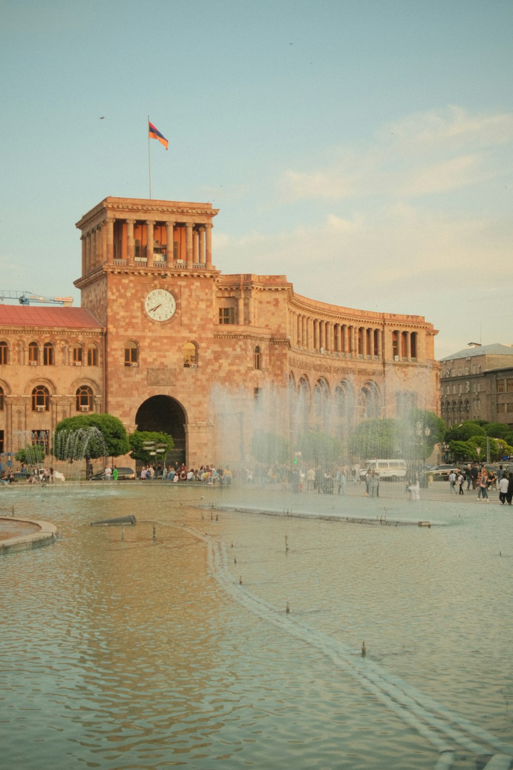 ein großes Gebäude mit einem Springbrunnen davor