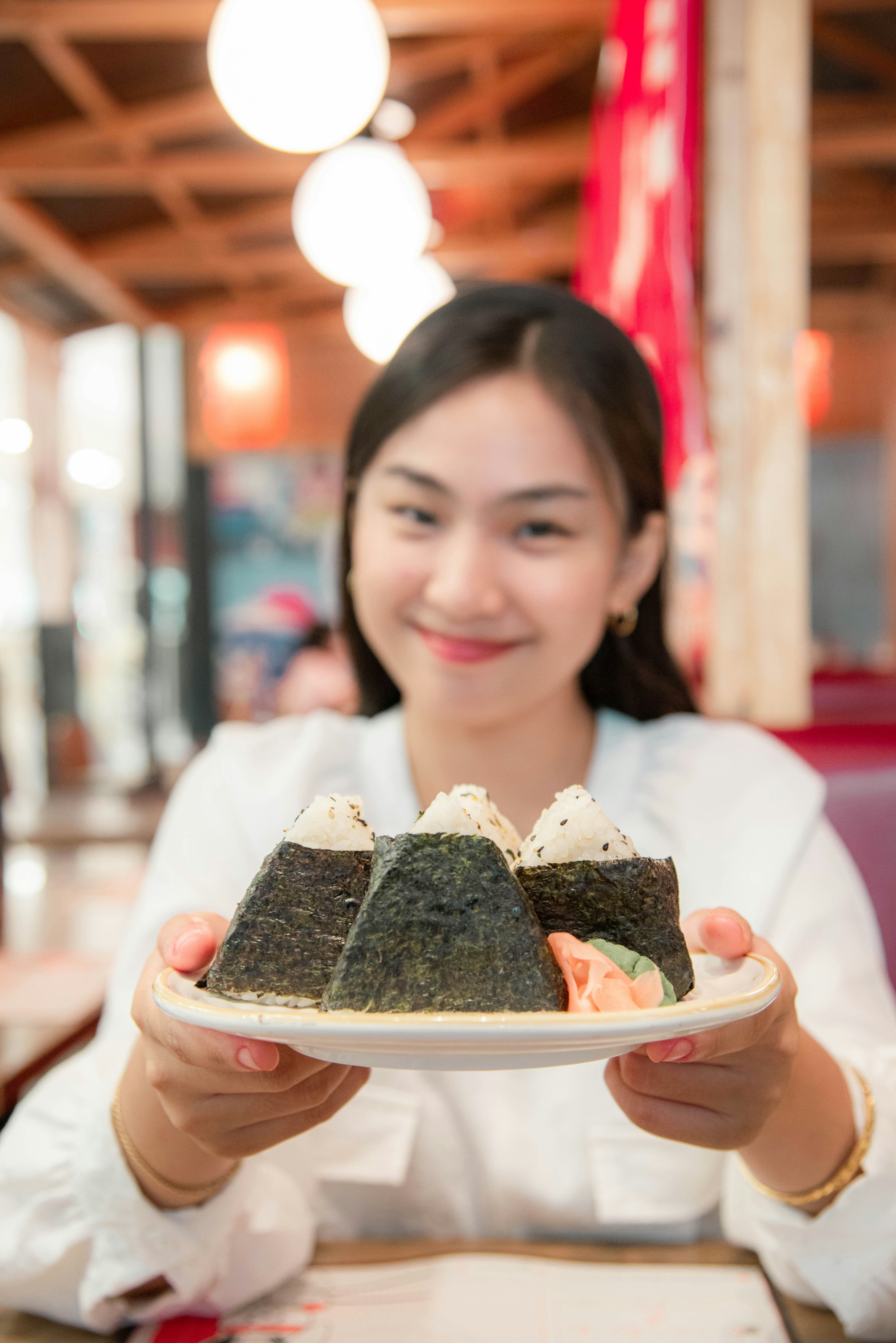una mujer sosteniendo un plato con sushi