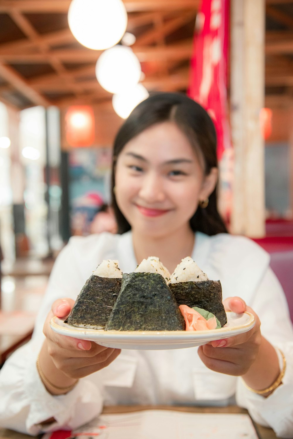 a woman holding a plate with sushi on it