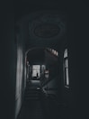 a dark hallway with a staircase leading to another room